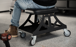Black Vyper Low Pro chair in garage next to black car