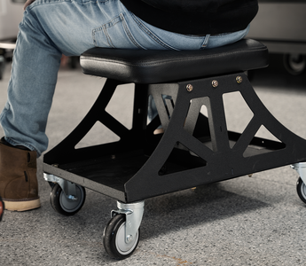 Black Vyper Low Pro chair in garage next to black car