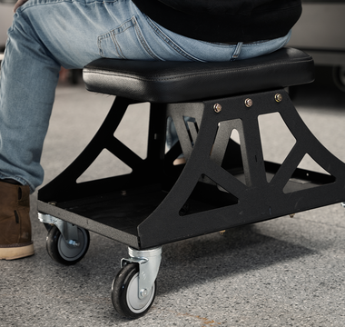 Black Vyper Low Pro chair in garage next to black car