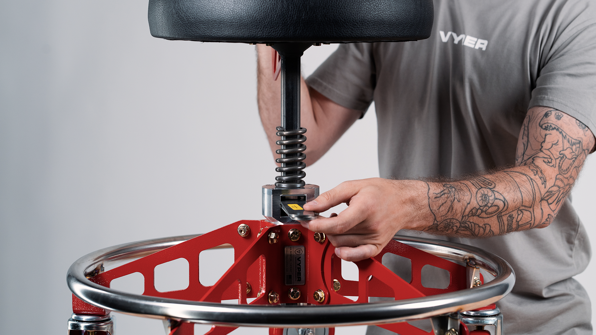 guy in blue jeans sitting on shop chair in dimly lit garage